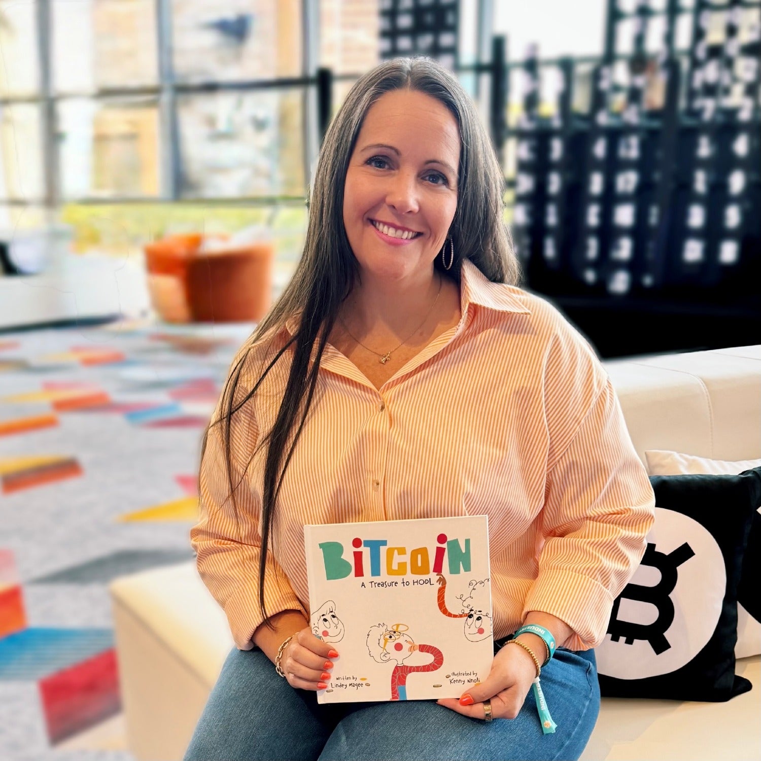 Author, Lindey Magee holding her book Bitcoin: A Treasure to HODL